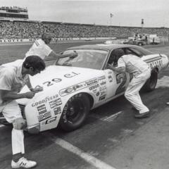 Owner Glen Wood talks with driver David Pearson. Delano Wood cleans the windshield. Crew chief Leonard Wood runs around the front of the car. - World 600 - 1973 - CMS Archives