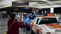 A fan stops for a photo of the NASCAR Hall of Fame display in the Nationwide Showcase Pavilion during opening day at the Charlotte AutoFair.